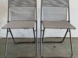 two folding chairs sitting next to each other in a room