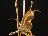 lampe en feuille d'or sur un socle en marbre, sur fond noir