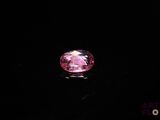 a close up of a pink diamond on a black surface