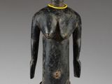an image of a wooden statue of a woman with a yellow necklace