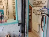 une photo d'une salle de bains où de nombreux vêtements sont suspendus au mur