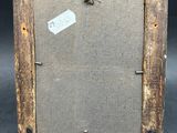an old picture frame with a tag hanging on it ' s side