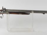 un vieux fusil au canon en bois, posé sur un socle transparent