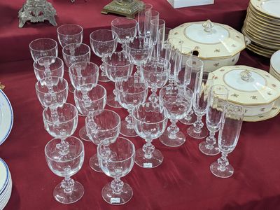 de nombreux verres et assiettes posés sur une table recouverte d'une nappe rouge