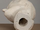 a white vase with a hole in it sitting on a table