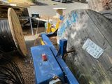 a blue machine that is sitting on the ground next to a pile of wires