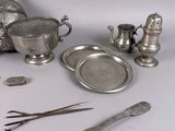 a silver plate and silverware on a white table
