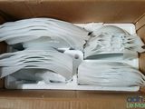 une boîte en carton contenant un tas de cuillères en plastique blanches