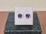 une paire de boucles d'oreilles en saphir bleu posées sur un bloc de marbre