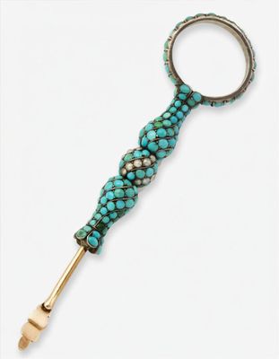 un gros plan d'un objet en métal orné de perles turquoise