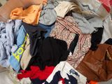 a basket full of clothes that is on a bed