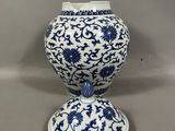 vase en porcelaine bleue et blanche orné d'un motif floral, sur socle