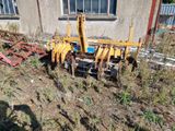 un tracteur qui est garé dans l'herbe près d'un bâtiment