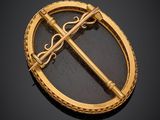 an image of a gold broochle with a cross on it