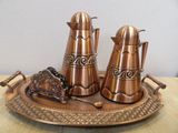 a metal tray with three different types of teapots on it