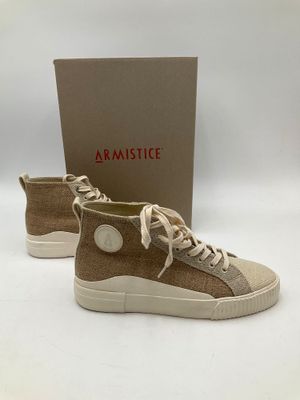 une paire de baskets beiges avec des lacets blancs et une boîte