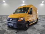 La camionnette jaune est garée sur un sol à damier dans le garage.