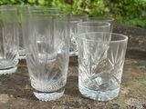 quatre verres posés sur une table à l'extérieur par une journée ensoleillée