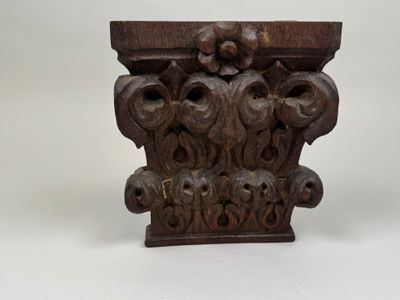 une corbeille ancienne en bois, ornée de motifs sculptés représentant des fleurs et des feuilles