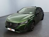 La voiture verte est garée dans une grande pièce aux murs blancs.