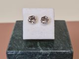 a close up of a pair of earrings sitting on top of a marble block