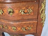a small wooden chest of drawers with a marble top