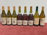 six bottles of wine are lined up on a table