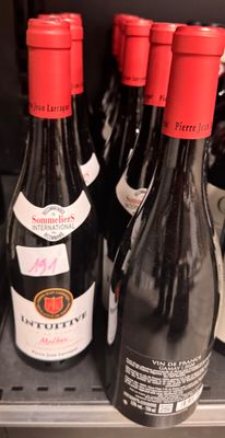 several bottles of wine sit on a shelf in a store