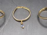 three gold rings with blue stones on them sitting next to each other