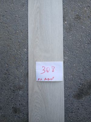 un gros plan sur un morceau de bois sur lequel est collé un autocollant