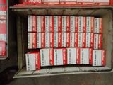 many boxes of cigarettes sitting in a box on the ground