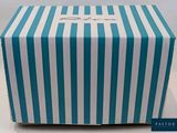 the blue and white striped box is sitting on the table