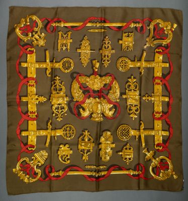 a square scarf with gold and red designs on it
