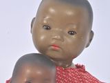 two dolls sitting next to each other on a table