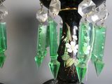 deux vases noirs ornés de fleurs vertes et blanches
