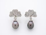 une photo d'une paire de boucles d'oreilles en perles noires et diamants