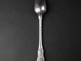 silver spoon on a black surface with a black background