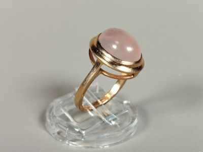bague avec une pierre rose sur une monture transparente