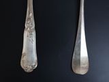 two spoons and a fork on a black table