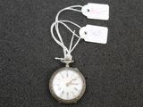 a silver pocket watch with tags attached to it