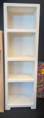 a white book shelf with three shelves next to each other