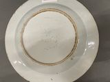 a white plate with a brown rim sitting on a table