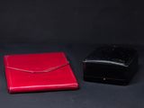 two red and black boxes sitting next to each other on a black surface