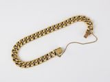a close up of a gold chain on a white surface