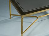 brass coffee table with a glass top and a black glass top