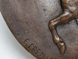 a bronze plaque with a horse and rider on it