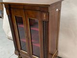a wooden cabinet with a glass door on the top