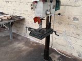 a machine that is sitting on a stand in front of a brick wall