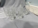 trois verres et un pichet posés sur une table
