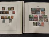 two pages of a book with stamps on them sitting on a table